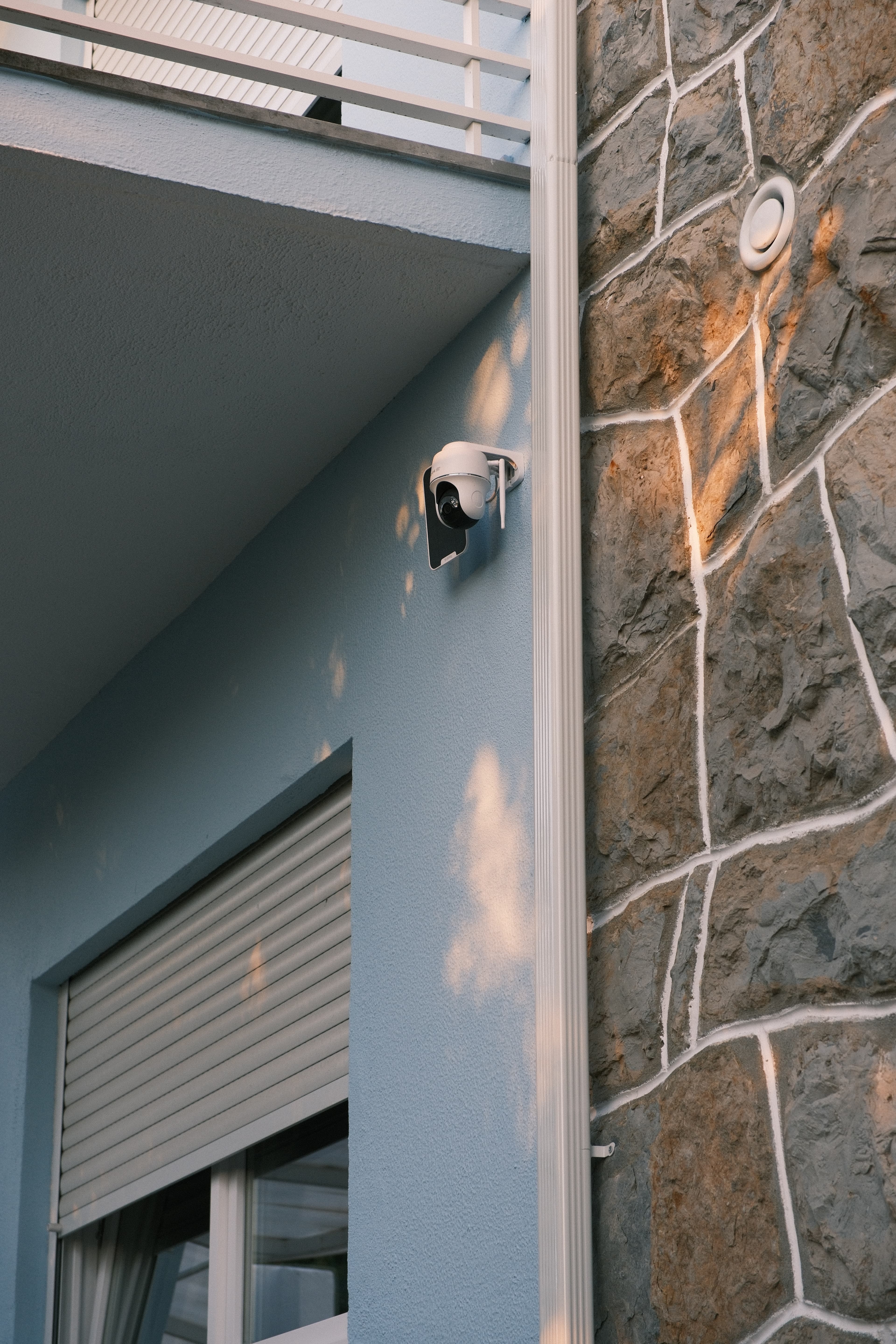 Detalhe de uma câmara exterior integrada junto à fachada de pedra da moradia